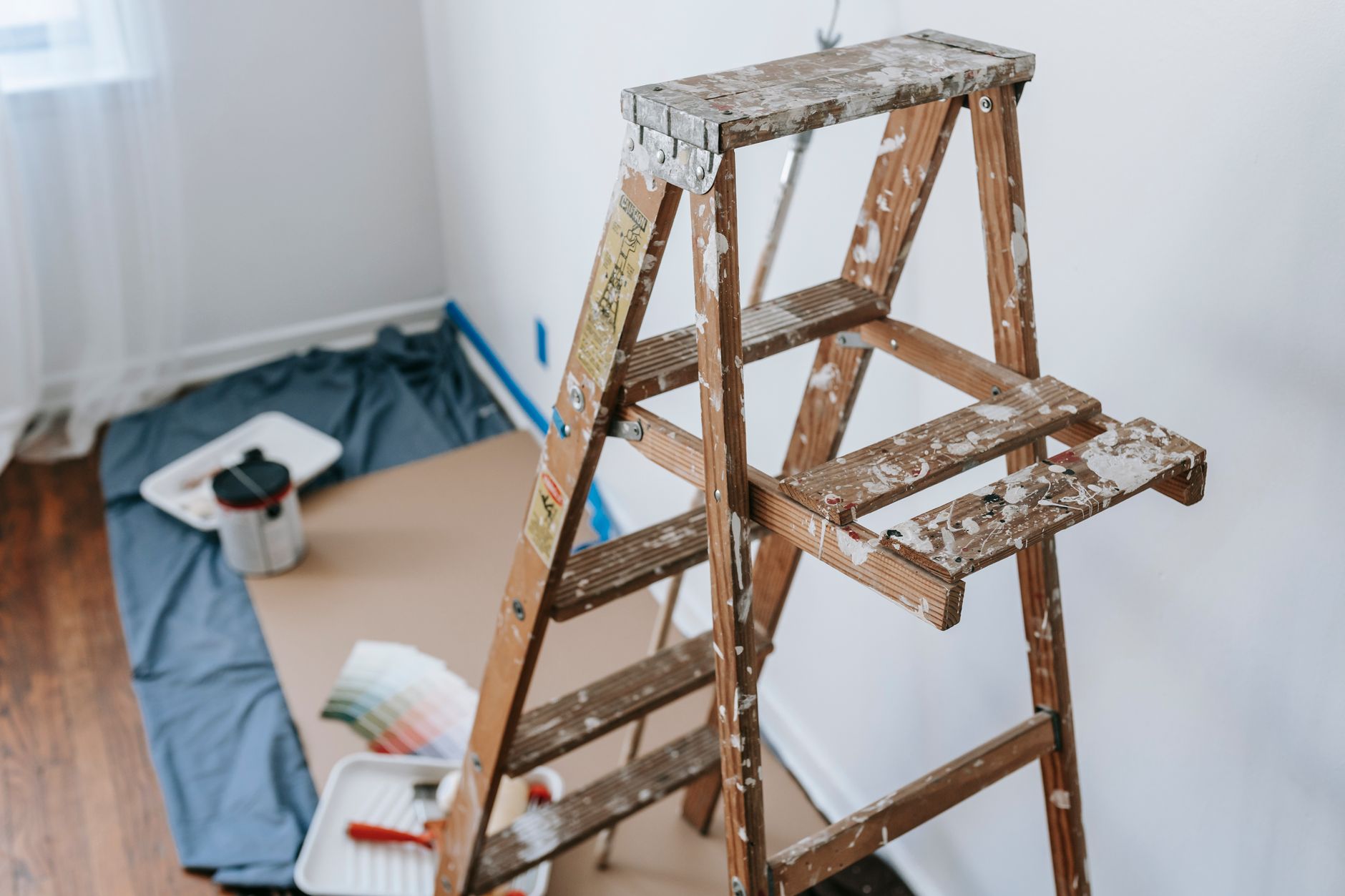 A messy stepladder and painting tools set up for a home interior renovation project in Santa Monica, CA